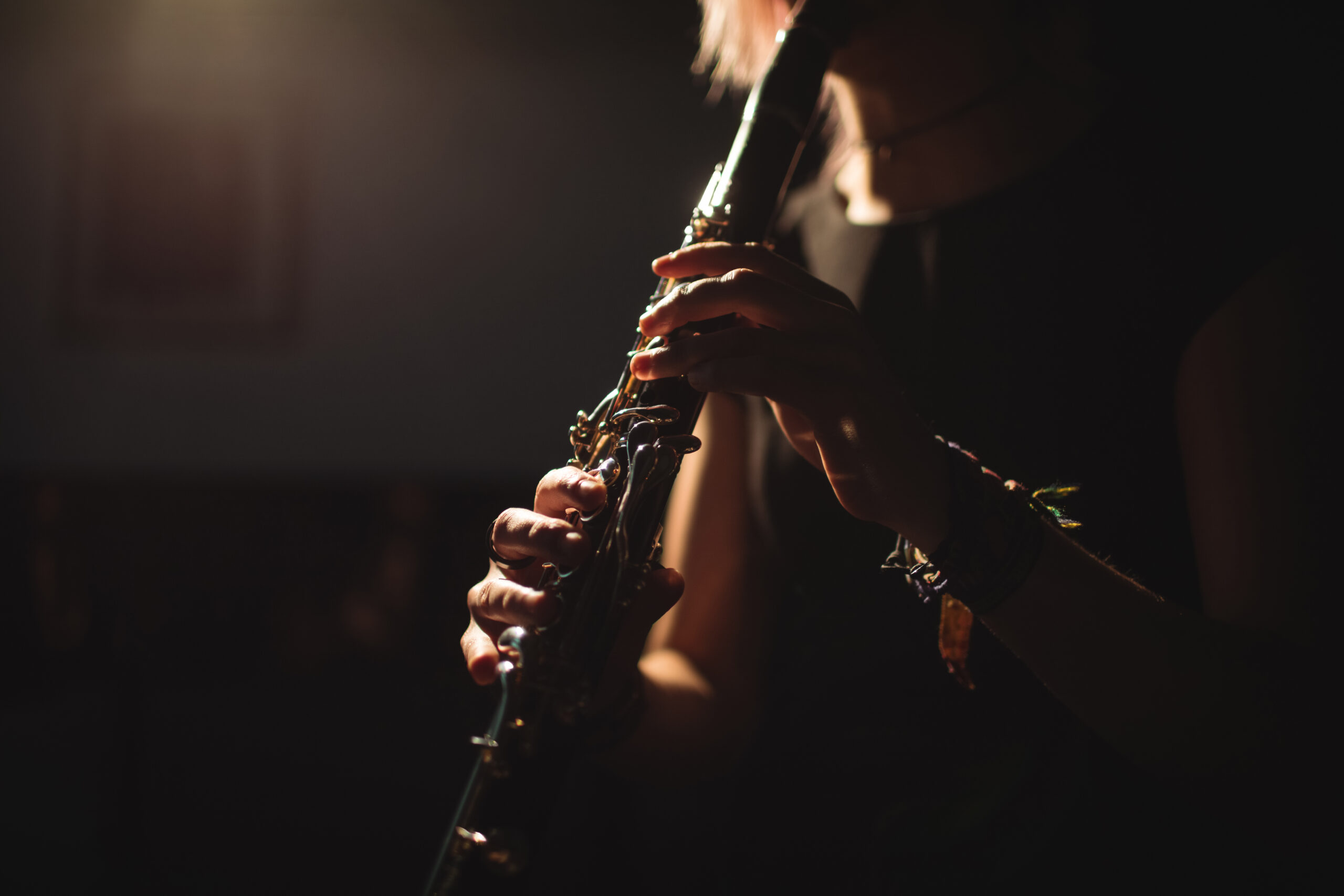 Mid-section of woman playing a clarinet in music school